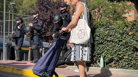 Una vecina de Móstoles se planta con el carro de la compra frente a los antidisturbios que desalojan el Edificio Dignidad, donde viven 18 familias.