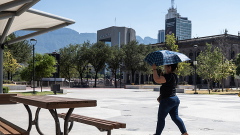 28/06/2023 - Una mujer sostiene una sombrilla para protegerse del sol debido a las altas temperaturas.