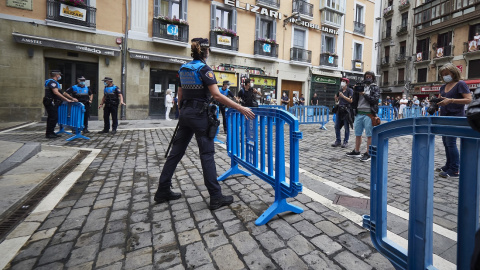 Una agente de policía coloca una valla en el arranque de los ‘No Sanfermines’, del 6 de julio de 2021, en Pamplona.