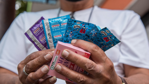 Un hombre sostiene preservativos durante las actividades de la campaña del Día Mundial del SIDA en Tailandia, Bangkok, el 1 de diciembre de 2021.