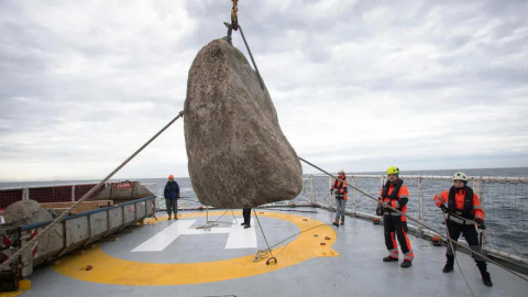 Operarios de Greenpeace se preparan para lanzar una roca gigante al mar. /Suzanne Plunkett / Greenpeace