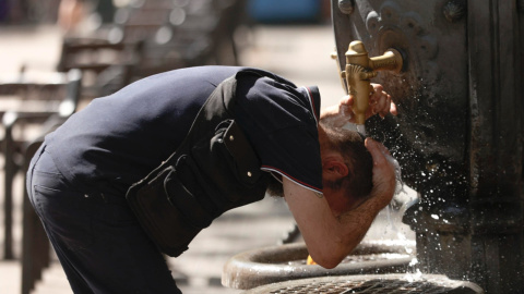 Un hombre se refresca en una fuente en el centro de Barcelona, este martes.