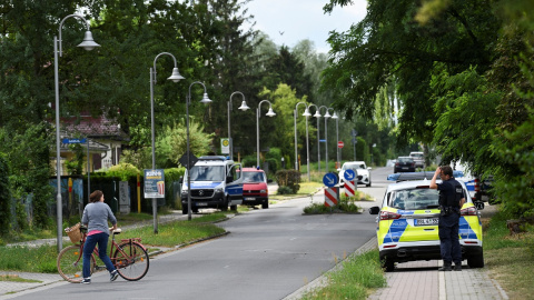 Una mujer con una bicicleta habla con un policía en una zona residencial después de que la policía de Berlín advirtiera al público que una supuesta leona andaba suelta en Stahnsdorf, cerca de Berlín , Alemania, el 20 de julio de 2023.