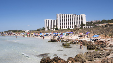 24/07/2023.- Varias personas disfrutan de la playa de frente al hotel Meliá Sol Son Bou en Alayor, Menorca este lunes.