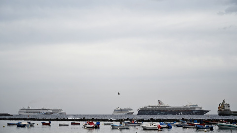 La gente disfruta de un baño mientras los cruceros están anclados en la playa de Los Cristianos, en la costa sur de la isla canaria de Tenerife, España, en el verano de 2021.