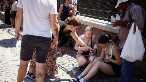 Una mujer sufre un golpe de calor en las calles de Roma durante la ola de calor del mes de julio de 2023.