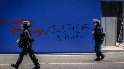 Policías antidisturbios frente a una pintada pidiendo "Justicia para Nahel" en París, Francia