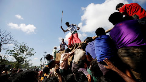 Un hombre usa una vara para controlar a la multitud mientras proporciona suministros de socorro a los refugiados Rohingya en el campamento de Cox, en Bangladesh. REUTERS / Mohammad Ponir Hossain