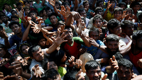 Los refugiados rohinya extienden su mano para alcanzar los suministros de socorro que les proporcionan las autoridades locales de Bangladesh, en el campamento improvisado de Cox. REUTERS / Mohammad Ponir Hossain