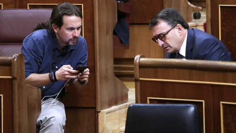 El líder de Podemos, Pablo Iglesias, y el portavoz del PNV, Aitor Esteban, conversan durante un pleno celebrado en el Congreso de los Diputados. EFE/Zipi