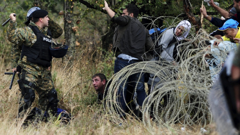 La Policía macedonia trata de detener a los refugiados que cruzan la frontera con Grecia, rumbo a Serbia, cerca de Gevgelija, Macedonia.- REUTERS / Ognen Teofilovski