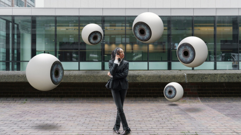 Una mujer es observada por varios ojos que flotan a su alrededor