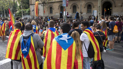 Centenares de estudiantes han cortado este viernes la Gran Vía de Barcelona en la plaza de la Universidad, donde han instalado una gran tarima con altavoces, para asistir a "clases en la calle" y han ocupado el edificio histórico de la Universitat de Ba