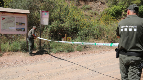 Dos Agents Rurals col·loquen una cinta per impedir l'accés al Parc Natural de la Serra de Montsant des de la Cartoixa d'Escaladei.