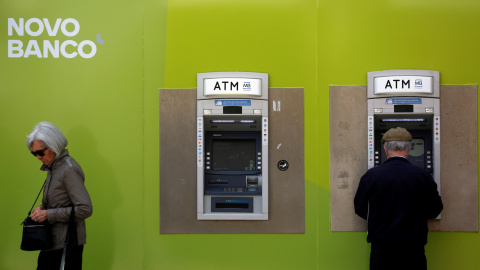 Dos ciudadanos pasan delante de una oficina de Novo Banco en Lisboa, Portugal.REUTERS/Pedro Nunes