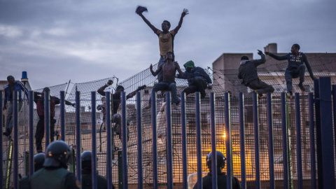 Inmigrantes subsaharianos encaramados a la valla de Melilla.- AFP