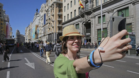 Una mujer se hace una fotografía en la Gran Vía de Madrid cerrada al tráfico con motivo del Día Sin Coches que, además de Madrid, celebran Valladolid, San Sebastián, y Valencia, entre 330 ciudades, con acciones que van desde limitar el tráfico priv