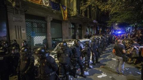 Agentes de los Mossos d'Esquadra custodian las puertas de la sede de la consellería de Economía de la Generalitat en cuyo interior se encontraba un grupo de agentes de la Guardia Civil que realizaban un registro con motivo del 1-O desde las ocho de la m