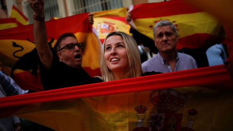 Una mujer con una bandera española en las calles de Barcelona. | REUTERS