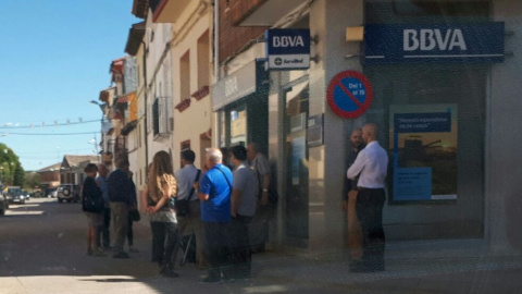 Decenas de clientes catalanes hacen cola ante la sucursal de BBVA de Belver de Cinca. / EDUARDO BAYONA