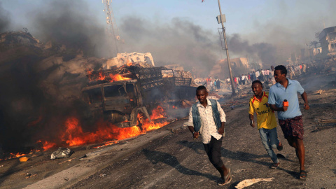 Varias personas huyen de la zona del atentado con camiones bomba contra un hotel y un mercado en MOgadiscio. REUTERS/Feisal Omar