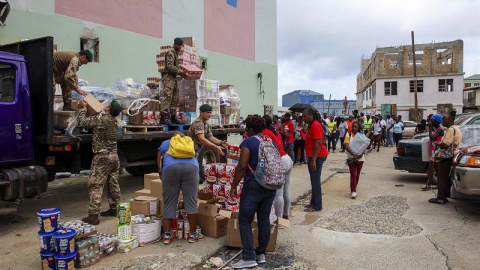 El equipo de marines y trabajadores de los servicios sociales de auxilio distribuye suministros a los habitantes de la isla para la preparación de la llegada del huracán María, en Road Town (Islas Vírgenes Británicas), el 18 de septiembre de 2017. El