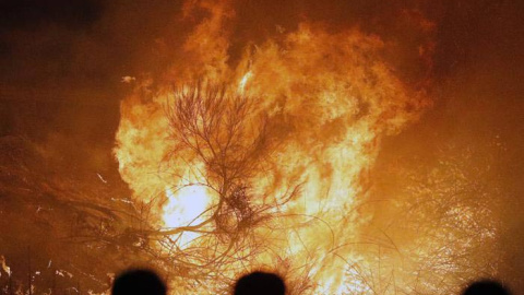 Varias personas observan un incendio en Chandebrito. | LAVANDEIRA JR. (EFE)