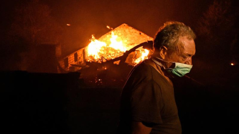 Un hombre entre las llamas en un incendio forestal declarado en Adica, Tondela (Portugal). / EFE