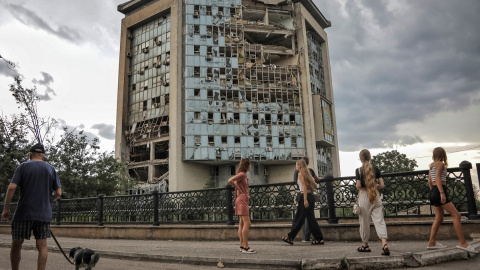 Varias personas pasan frente a un edificio destruido en un ataque ruso con drones en Izmail, en la región ucraniana de Odesa, a 2 de agosto de 2023