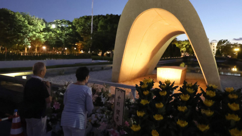 Dos personas rezan ante el Parque Conmemorativo de la Paz, en Hiroshima, en recuerdo a las víctimas de la bomba atómica este 6 de agosto de 2023.