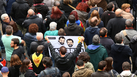 Un manifestante con una pancarta reclamando la puesta en libertad de los presidentes de ANC y Omnium Cutural, Jordi Sanchez y Jordi Cuixart, respectivamente, en la concentración en la Plaza de Sant Jaume durante la jornada de huelga general en Catalunya.