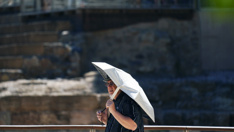 Varias personas intentan protegerse de las altas temperaturas que azotan estos días la capital malagueña, a 3 de agosto de 2023 en Málaga, (Andalucía).