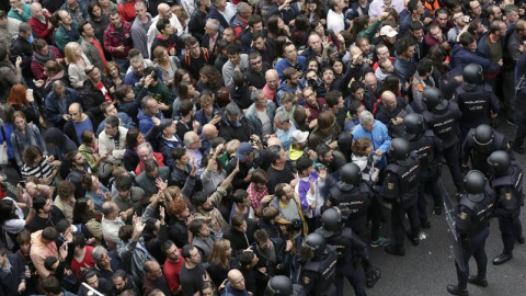 Policía Nacional y Guardia Civil ante los concentrados en el colegio Ramón Llull de Barcelona./ EFE