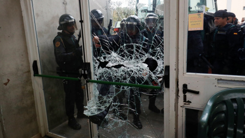 La Policía destroza la puerta del colegio electoral donde tenía que votar Carles Puigdemont./ REUTERS