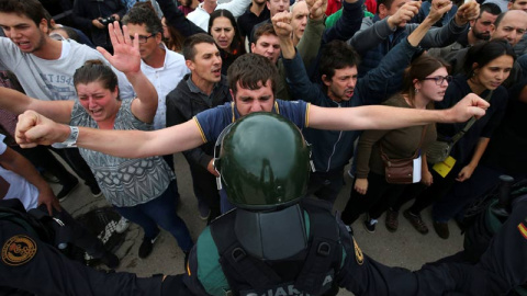 Un joven se enfrenta a un agente de la Guardia Civil. | REUTERS