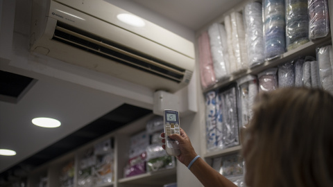 Foto de archivo. Una trabajadora pone el aire acondicionado a 27 grados, en Barcelona.