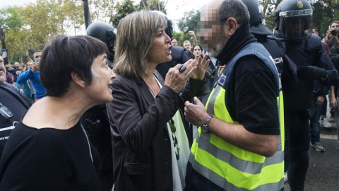 La alcaldesa de L'Hospitalet de Llobregat, Nuria Marin, se enfrenta a un policía fuera de la Escuela Can Vilumara. EFE/Quique García