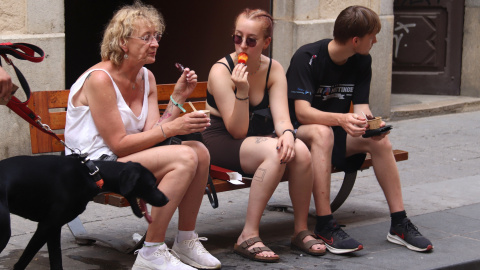 Tres turistes es mengen un gelat al carrer de Santa Clara de Girona