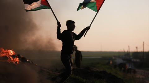 Un manifestante con la bandera de Palestina en la frontera de Gaza protesta tras los últimos ataques contra un campamento de refugiados en Yenín.