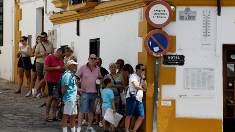 Personas haciendo cola en la sombra para evitar el fuerte sol, en Ronda, a 7 de agosto.