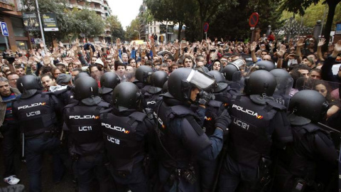 Agentes antidisturbios de la Policía Nacional forman un cordón de seguridad en los alrededores del colegio Ramón Llull de Barcelona. | EFE