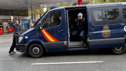 Un manifestante se coloca delante de una furgoneta de la Policía Nacional cerca de un colegio electoral en Barcelona durante el referéndum del 1-O. REUTERS/Yves Herman