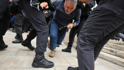 Agentes de la Guardia Civil tiran de un ciudadano frente a un colegio electoral en Sant Julia de Ramis, este domingo. REUTERS/Albert Gea