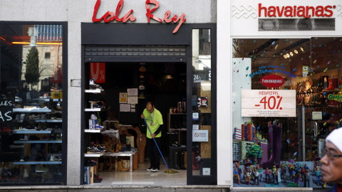 Un empleado de una tienda en el centro de Madrid limpia la entrada del establecimiento. REUTERS