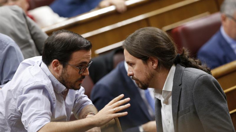 El secretario general de Podemos, Pablo Iglesias (d), conversa con el coordinador general de IU, Alberto Garzón (i). /EFE