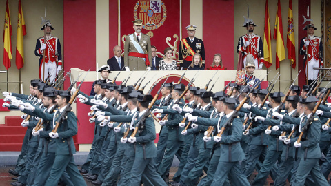 El rey Felipe VI, acompañado de su familia, presencia el paso de una unidad de la Guardia Civil durante el desfile militar del 12-O de 2016. JUANJO MARTÍN/EFE