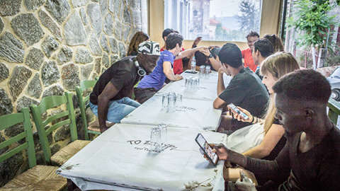 Algunas personas en movimiento de Lesbos se sientan en una de las tabernas centrales de Agiasos, Stavi Tavern, junto con algunos voluntarios de la asociación Yoga y Deportes con Refugiados, después del Agiasos Mountain Trail. En la foto, primero a la de