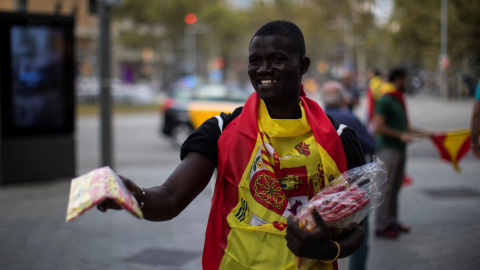 Un vendedor callejero ofrece banderas españolas en Barcelona durante el día de la Fiesta Nacional. REUTERS/Juan Medina