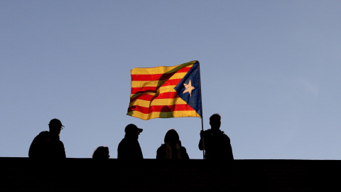 Varios vecinos ondean una senyera en una terraza durante la manifestación convocada en Barcelona por la ANC y Ómnium para exigir la libertad de los 'Jordis' y los miembros del Govern cesados y encarcelados por orden de la Audiencia Nacional. EFE/Alberto