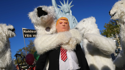 Un manifestante vestido con una máscara del presidente de EEUU Donald Trump junto a otros manifestantes disfrazados de osos polares, durante una manifestación de organizaciones ecologistas en Bonn, ante la cumbre del  clima COP23. REUTERS / Wolfgang Rat